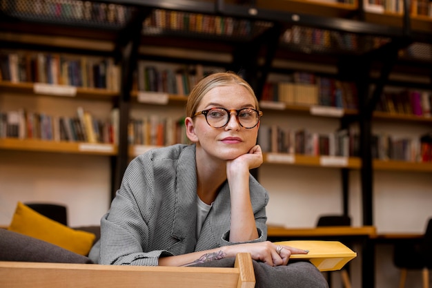 Hübsches junges Mädchen, das an der Bibliothek aufwirft