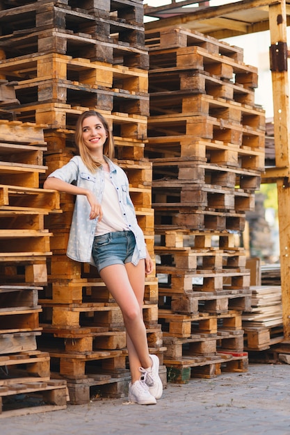 Hübsches lächelndes Mädchen, tragende Jeans, kurze Hosen und Hemdaufstellung