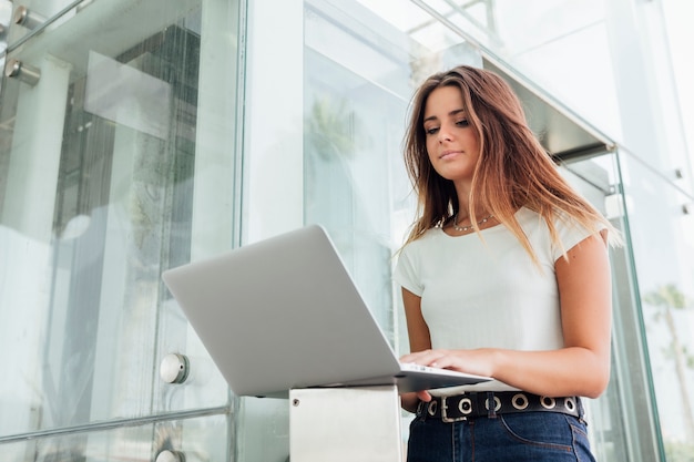 Hübsches Mädchen, das das Internet auf einem Laptop durchstöbert