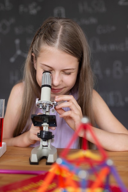 Kostenloses Foto hübsches mädchen, das im unterricht mehr über chemie lernt