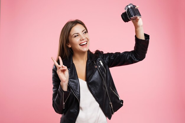 Hübsches Mädchen, das Selfie auf alter Rollfilmkamera nimmt