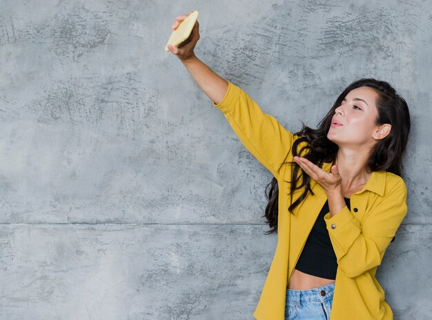 Hübsches Mädchen des mittleren Schusses, das ein selfie nimmt