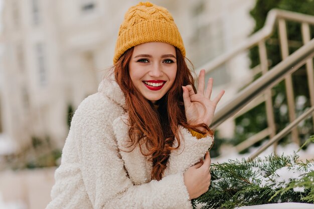 Hübsches Mädchen mit langen dunklen Haaren, die im Winter lachen. Außenaufnahme der romantischen kaukasischen Frau, die im kalten Tag kühlt.