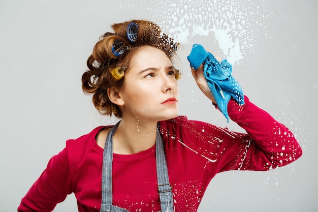 Kostenloses Foto hübsches mädchen wahses fenster mit blauem handtuch vorsichtig