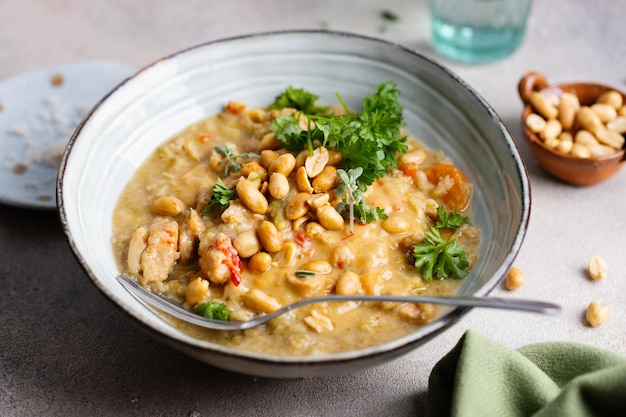 Hühnchen in currysauce, serviert in einer schüssel mit stäbchen auf dem tisch. nahaufnahme