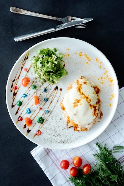 Hühnchen mit geschmolzenem Käse, serviert mit Salat