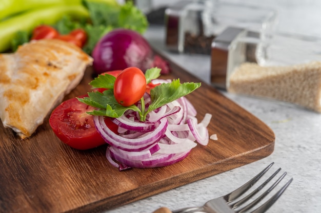 Hühnchensteak auf ein Holztablett gelegt.