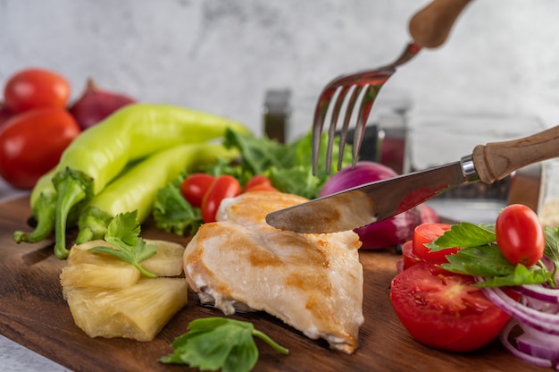 Hühnchensteak auf ein Holztablett gelegt.