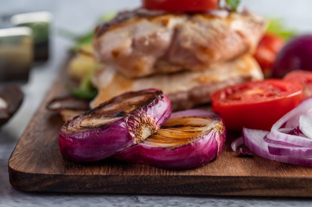 Hühnchensteak auf ein Holztablett gelegt.