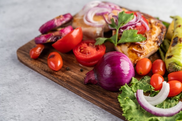 Hühnchensteak auf ein Holztablett gelegt.