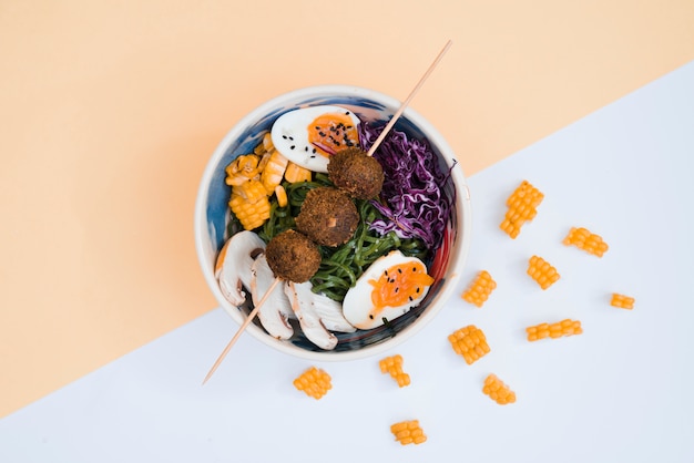 Kostenloses Foto hühnerbälle im stock über der schüssel mit salat und eiern auf doppelhintergrund