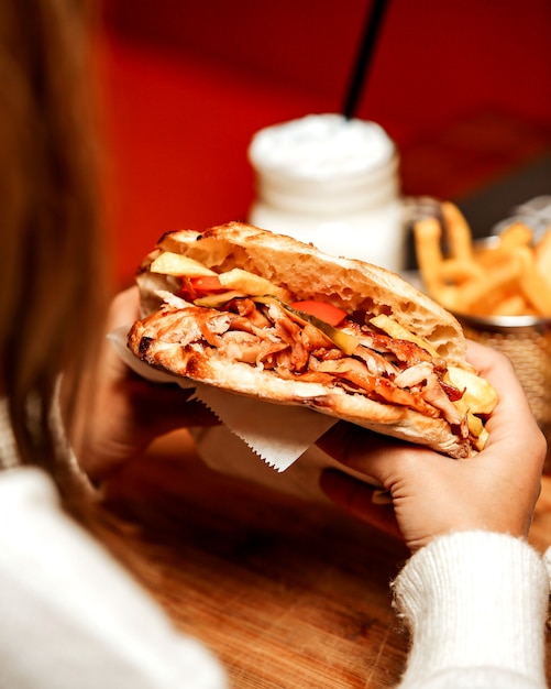 Hühnerdöner in einem runden Tenir mit Pommes Frites