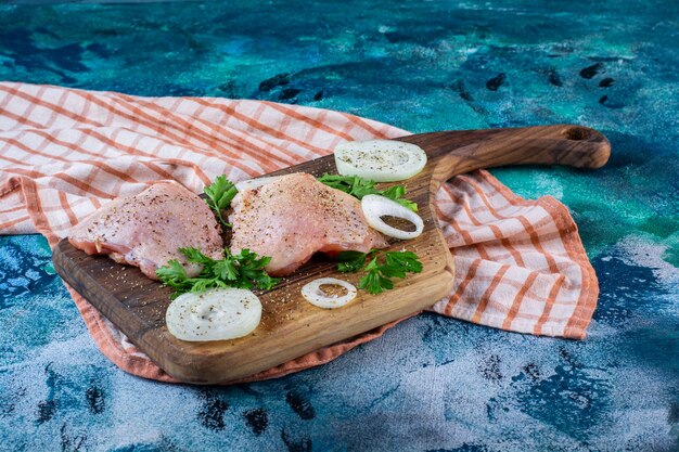 Hühnerfleisch auf einem Schneidebrett auf dem Geschirrtuch