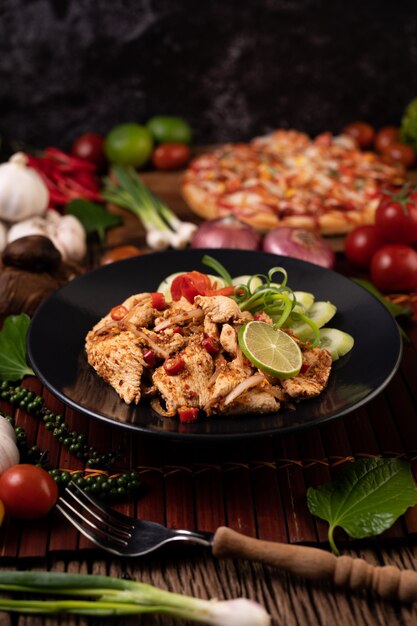 Hühnerlarb auf dem Teller Mit getrockneten Chilis, Tomaten, Frühlingszwiebeln und Salat