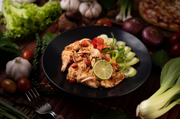 Kostenloses Foto hühnerlarb auf dem teller mit getrockneten chilis, tomaten, frühlingszwiebeln und salat