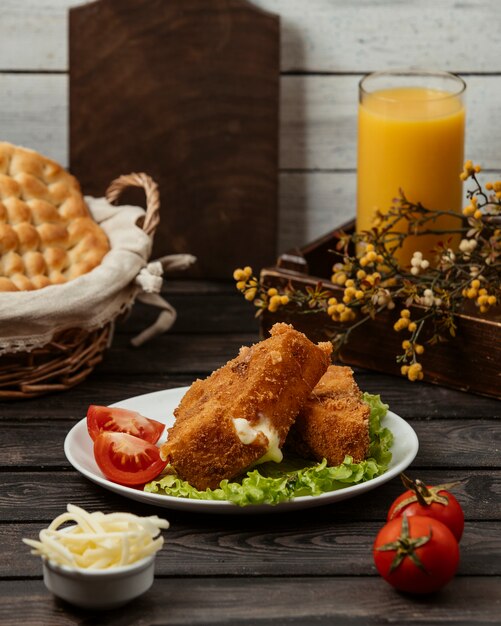 Hühnernuggets mit Tomate und Kopfsalat.