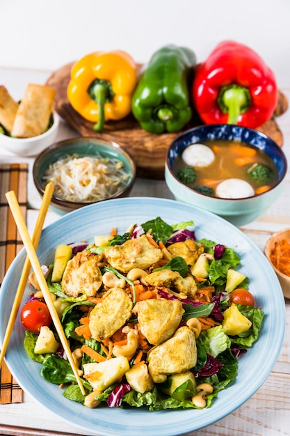 Kostenloses Foto hühnersalat mit essstäbchen; bohnensprossen- und fischballsuppe auf tabelle