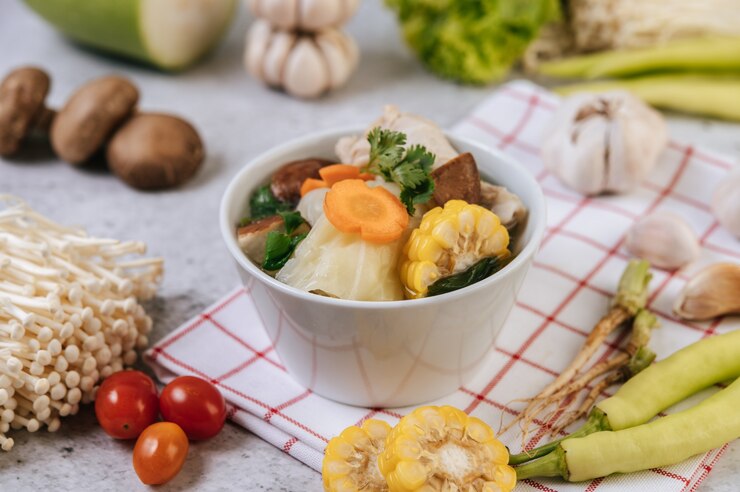 Kostenlose Foto hühnersuppe mit mais, shiitake-pilz, enoki-pilz und karotte.