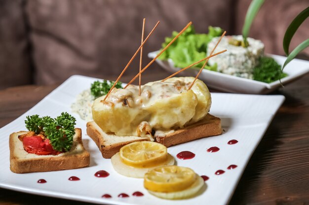 Huhn mit Pilzen in Kartoffel auf Toastbrot Tomaten Zitronensauce Seitenansicht