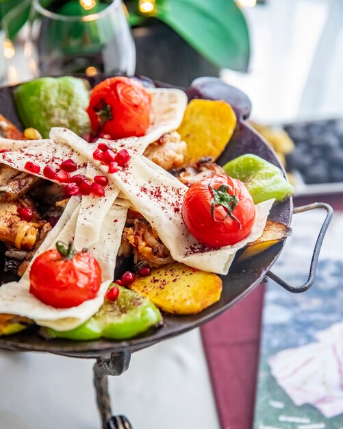 Kostenloses Foto huhn sadj kartoffel tomate paprika lavash granatapfel seitenansicht