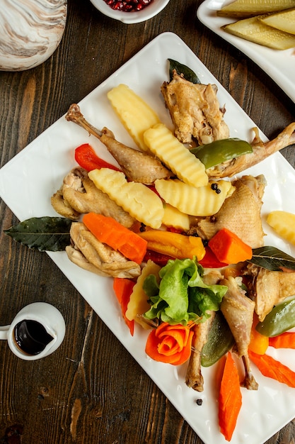 Huhn serviert mit Kartoffeln Karotten und Salat