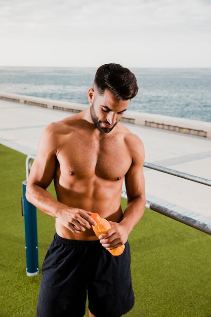 Hydratation des gutaussehenden Mannes nach dem Training im Freien