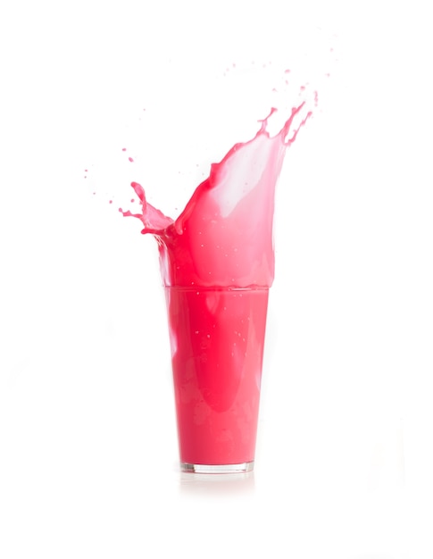 Ice fallen in ein Glas mit rosa Getränk