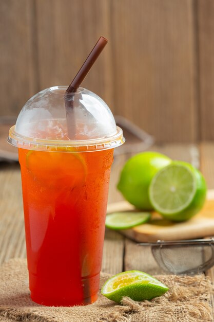 Iced Lemon Tea Glass mit Honig Zitrone Auf einer Holzwand.