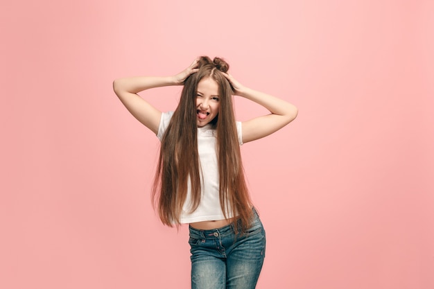 Ich habe den Verstand verloren. Das jugendlich Mädchen mit seltsamem Ausdruck. Schönes weibliches halblanges Porträt lokalisiert auf rosa Studiohintergrund. Der verrückte Teenager. Die menschlichen Emotionen, Gesichtsausdruck Konzept.