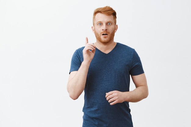 Ich habe es verstanden, habe eine Idee. Gut aussehender reifer europäischer Kerl mit Borste im blauen T-Shirt, das Zeigefinger hebt, nach Luft schnappt, intensiv starrt, Vorschlag macht oder Plan erzählt, Eureka-Geste zeigend