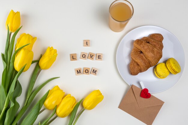 Ich liebe Mom Inschrift mit Tulpen und Croissant