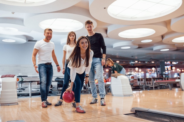 Ich schaue geradeaus. Junge fröhliche Freunde haben an ihren Wochenenden Spaß im Bowlingclub