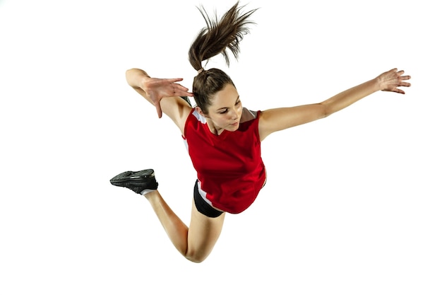 Im sprung und im flug. junge weibliche volleyballspielerin lokalisiert auf weißem studiohintergrund. frau in sportbekleidung und turnschuhtraining, spielend. konzept von sport, gesundem lebensstil, bewegung und bewegung.