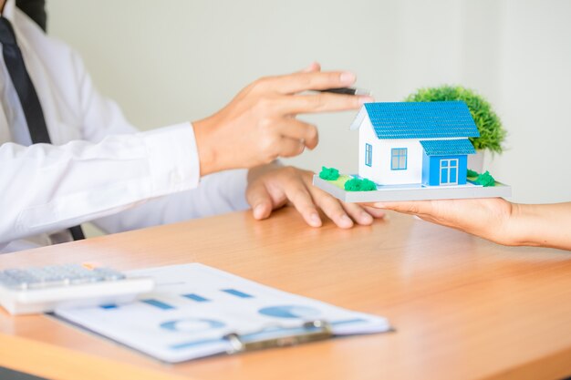 Immobilienmakleragent, der dem Kunden zur Entscheidungsfindungszeichen-Versicherungsformularvereinbarung darstellt und sich berät