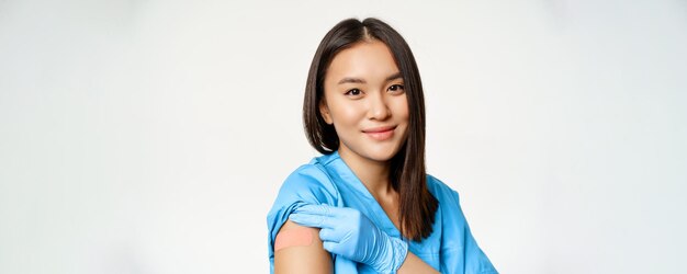 Impfprogramm und Covid-Konzeptporträt des asiatischen Gesundheitspersonals in medizinischer Robe, das va zeigt