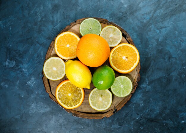 In Scheiben geschnittene Orange mit Limette, Zitronenflach auf grungy blauem und Holzbrett