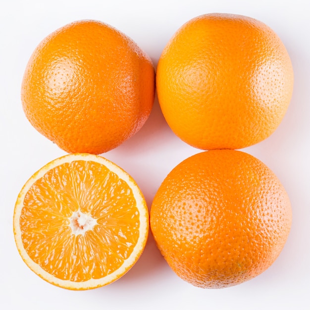 Kostenloses Foto in scheiben geschnittene und ganze orangen