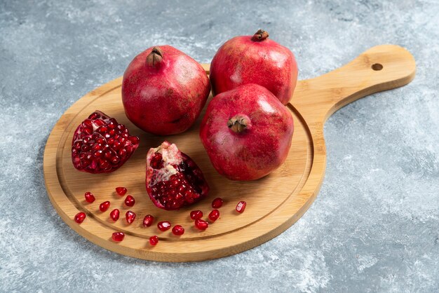 In Scheiben geschnittener reifer Granatapfel auf einem Holzbrett.