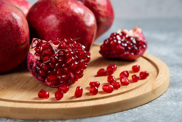 In Scheiben geschnittener reifer Granatapfel auf einem Holzbrett.