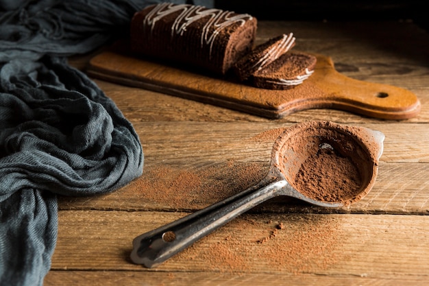 In scheiben geschnittener schokoladenkuchen mit hohem winkel und sieb mit kakaopulver