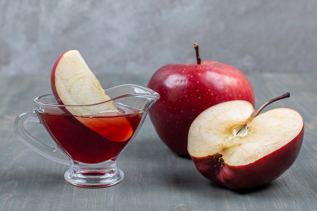 In Scheiben geschnittener und ganzer roter Apfel mit Saft