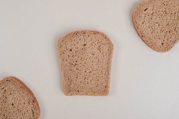 In Scheiben geschnittenes frisches Schwarzbrot auf weißer Oberfläche