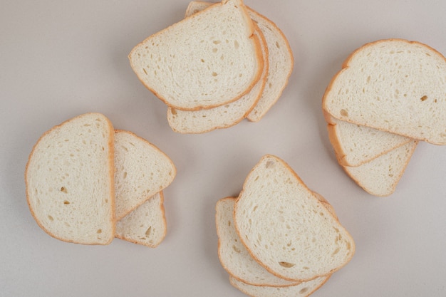 In Scheiben geschnittenes frisches Weißbrot auf weißer Oberfläche