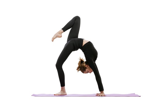 In voller Länge Porträt von younf sportliches Mädchentraining beim Yoga und Dehnübungen isoliert auf weißem Hintergrund