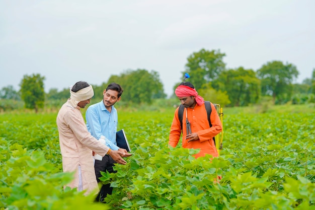 Indischer bauer im gespräch mit agronom bei farm und sammeln von informationen