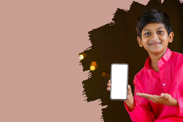 Indisches kleines kind in traditioneller kleidung und mit smartphone Premium Fotos