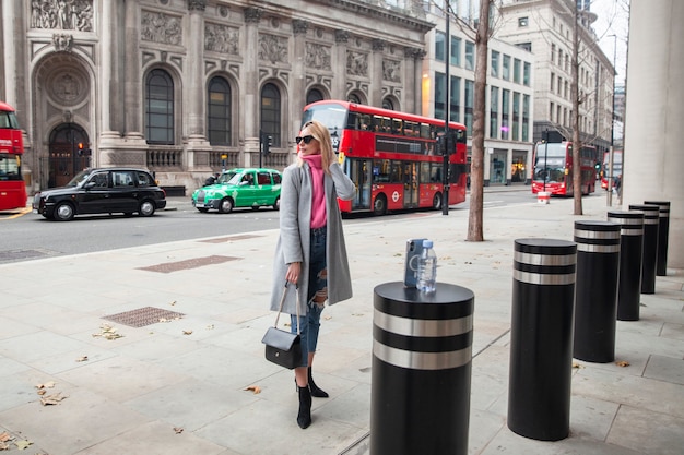 Influencer macht ein Selfie mit einem Smartphone, das auf einem Pylon in der Stadt steht