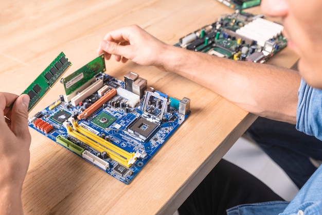 Ingenieur, der das RAM-Speichermodul in Motherboard setzt