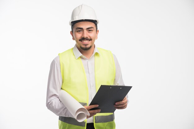 Ingenieur in Uniform, der die Aufgabenliste überprüft und lächelt.