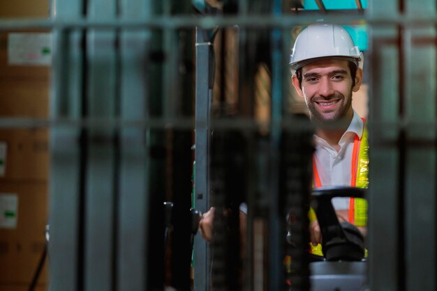 Ingenieurpersonal männlicher Lagerarbeiter mit Schutzhelm, der durch Logistikzentrum Lager Fabrik Baustelle Logistik Architekt Forklife Fahrer Mann Baumeister drinnen Hintergrund arbeitet